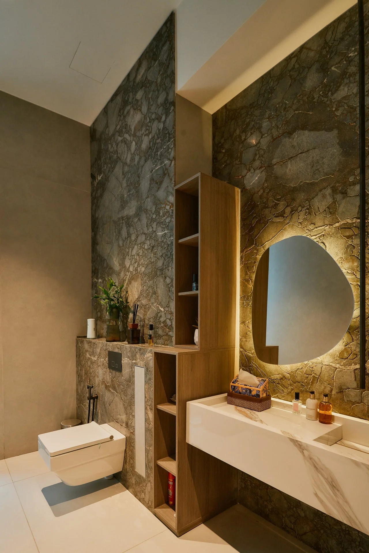 Feature stone wall with an illuminated mirror and floating vanity