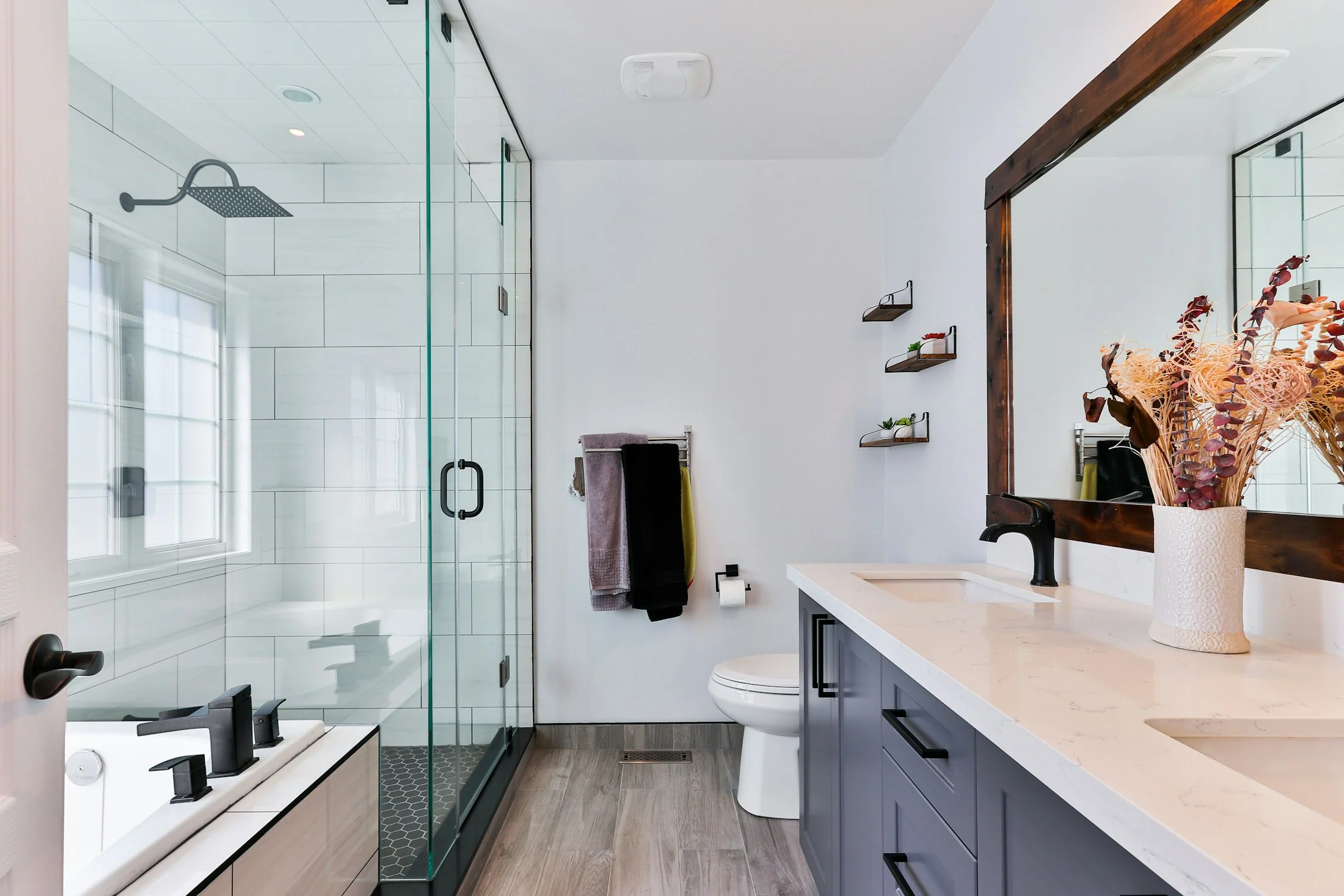 Bright finished bathroom with a frameless glass shower and floating vanity